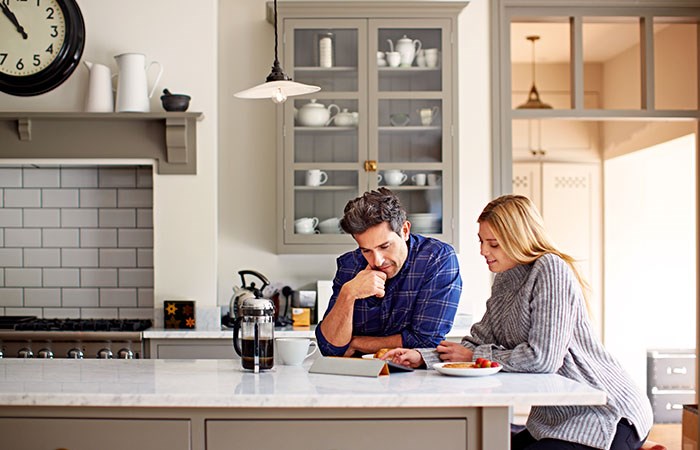 Par i modernt kök diskuterar värmelösning till hemmet