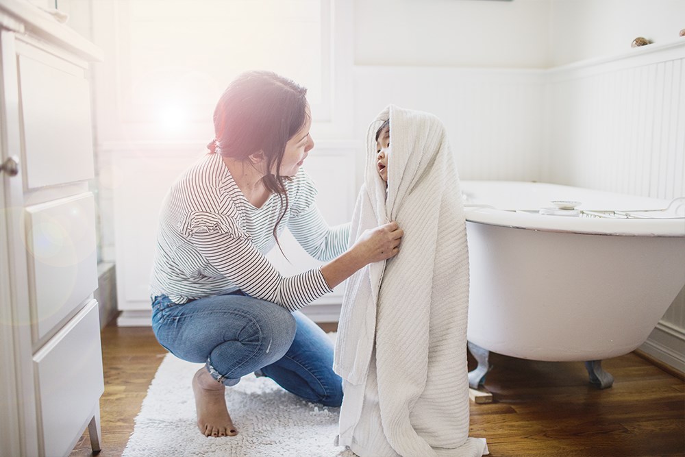 Mamma torkar nybadat barn med handduk