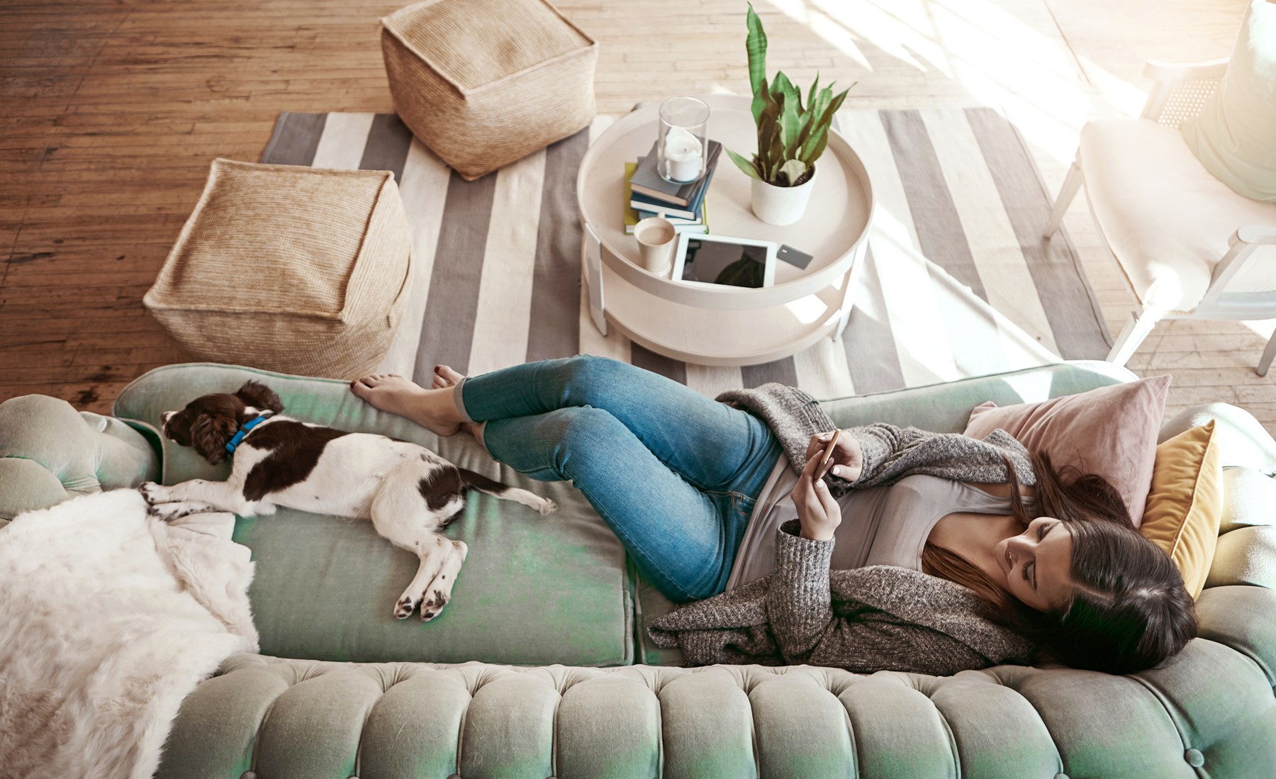 Kvinna och hund njuter i soffan av luftvärmepumpen