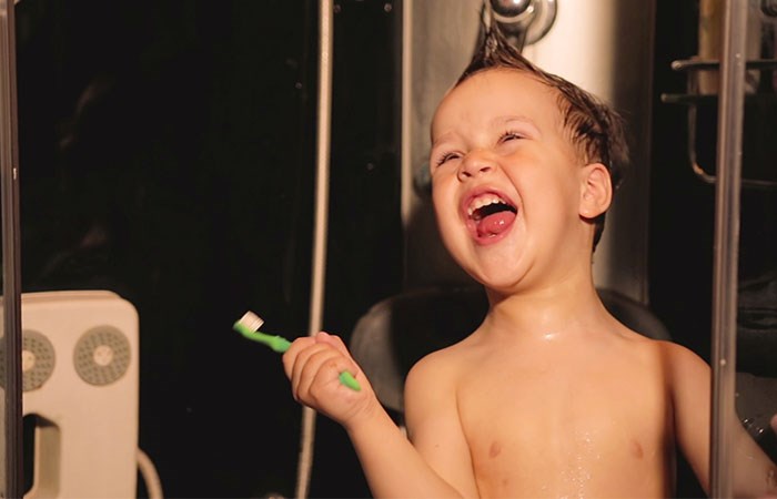 Liten pojke sjunger i duschen 